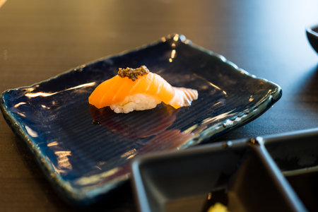 Tasty classic salmon sushi on black dishの写真素材