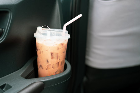 An iced mocha coffee drink placed in a cup holder inside a car.の写真素材