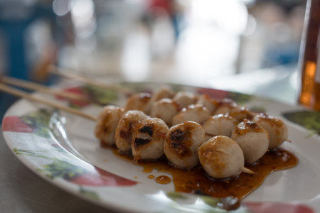 Grilled pork meatballs with sweet sauce on skewers are tendon street food of Thailand.の写真素材