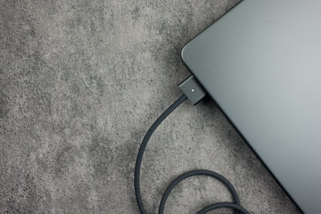 Bangkok, Thailand - December 29, 2023 : Close up a black braided USB-C cable charge and connect to...