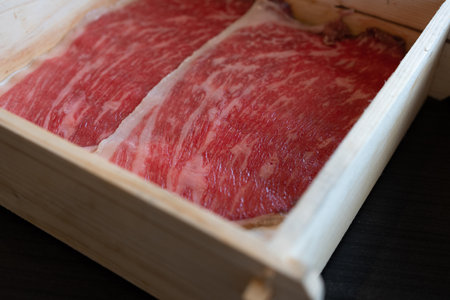 Rare sliced beef with a marbled texture served on a wood box. Premium quality beef. Close upの写真素材