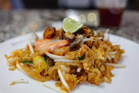 Pat Thai, rice noodles fried with tofu, vegetable, egg and seafood on plate in Thailandの写真素材