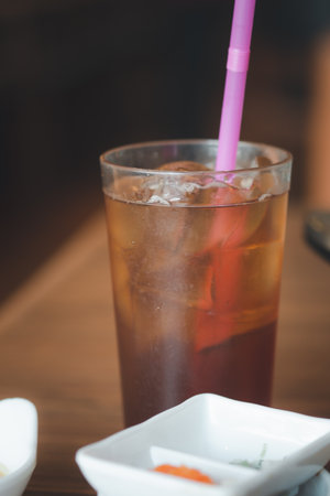 Glass of ice tea with pink straw. Close upの写真素材