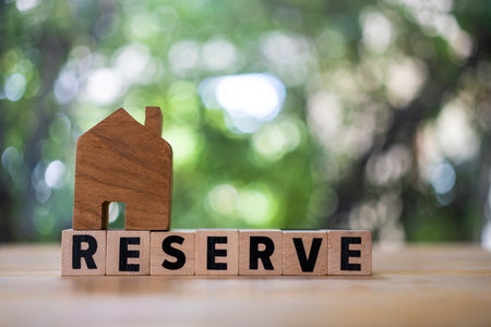 The concept of reserve home against nature background with copy space. Text of reserve with house models on top, real estate marketの写真素材