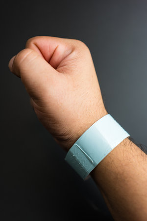 Empty concert bracelet on hand, mockup on a black background. Event ticket conceptの写真素材