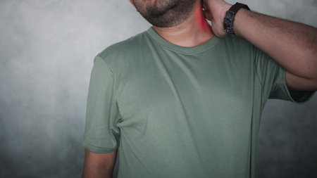 A handsome man suffering from neck pain. Health problem and office sindrom concept
