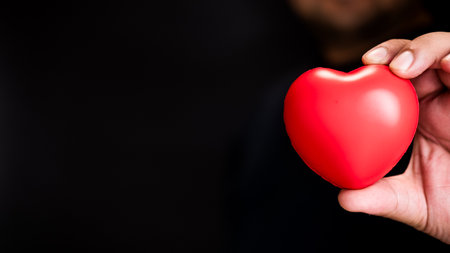 Red heart in man hands. Healthcare concept, organ donation concept. Symbolic of Valentine day. Heart day with copy space.の写真素材