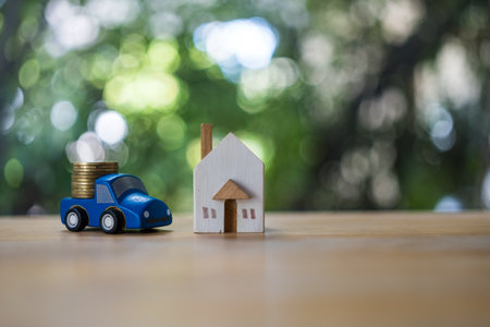 Wood toy truck carry stack of coins deliver to home. The concept of bank delivery service money to home customer. Deliver or sending of money to home.の写真素材