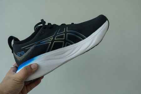 Bangkok, Thailand - January 7, 2024 : Man hand holding a shoe of ASICS Running Shoes Gel Nimbus 25 WIDE. Shoe sport sneakers for joggingのeditorial素材