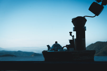 Image of a woman making drip coffee with a beautiful mountain and nature view in backgroundの写真素材