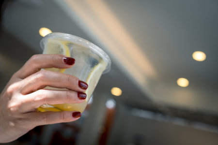 Cool freshly made lemonade and fruits in women at coffee shop