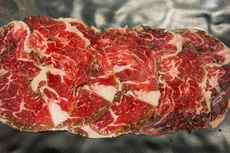 Sliced ââfresh raw beef served on black plateの写真素材
