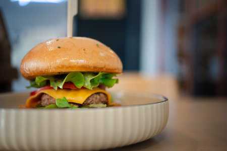 Delicious burger with vegetables, pork and cheese served in bowlの写真素材