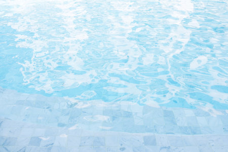 Swimming pool edge, close up background. Clear blue water in the poolの写真素材