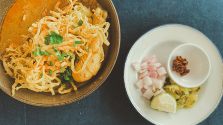 Northern Thai food it called Khao Soi Kai, egg noodle soup with chicken and a mix of deep fried egg noodles served with pickled mustard greens, shallots and limeの写真素材