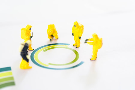 Miniature scale model team in chemical suit Standing in a circle. Chemical team examining integrated circuit.の写真素材