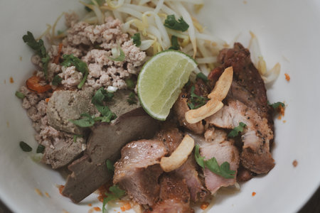 Thai dry noodle with minced pork, entrails in white bowl ceramic. Thai noodles. Delicious dry noodles in thai style food on country styleの写真素材