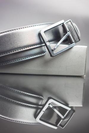 Leather black belt with metal buckle on black boxの写真素材