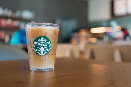 Bangkok, Thailand - January 19, 2024 : Coffee refresher beverage served on crystal glass with Starbucks logo against coffee shop blur background. Starbucks is the largest coffeehouse companyのeditorial素材