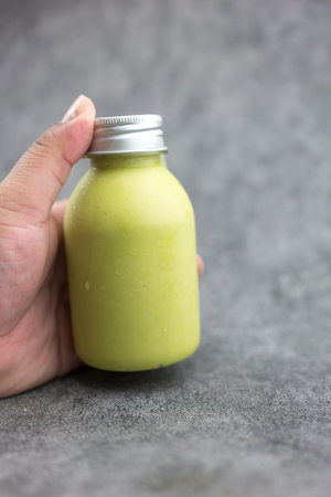 A man choose freshly prepared smoothie of avocado, fresh milk and huney. Diet vegetarian food.の写真素材