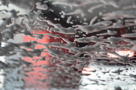 Foam on the windshield. Wash the dirt from the machine with foam. Automatic car wash.の写真素材