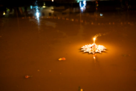 Blur picture of a lights of Kratong make from paper floating alone on a pond during in Loy Kratong festival night in Thailandの写真素材