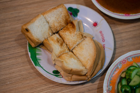 Grilled toasted bread cut into bite-sized pieces for side dish with pork satay sticks. Close upの写真素材