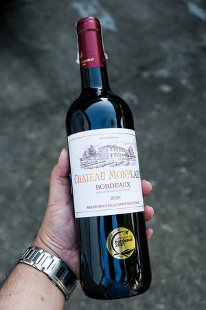 Bangkok, Thailand - February 8, 2024 : A bottle of red wine from Bordeaux, France in handのeditorial素材