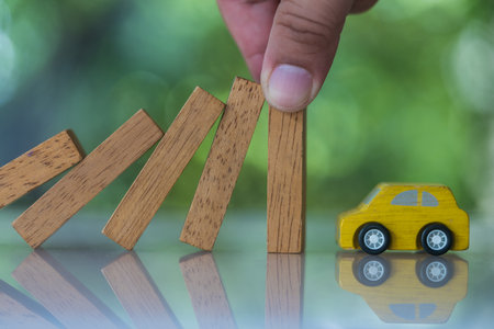 Car insurance Insurance. Hands stop the effects wooden blocks from falling to car. Business risk and strategy, Insurance conceptの写真素材
