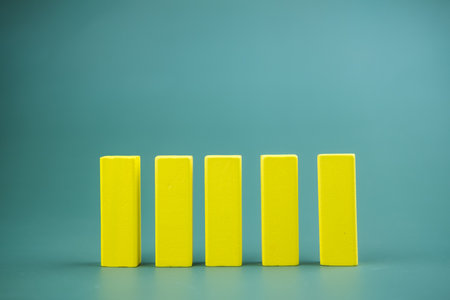 Five yellow wood block on a green background. It's lined up so you can fit in data. Front viewsの写真素材