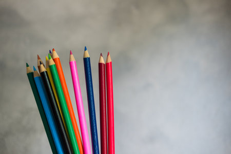 Hands with paints, hold a bunch of colored pencils for drawing, hobbies. The colors of the rainbowの写真素材