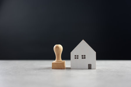 Rubber stamp and model home on table with black background, approved application contract, bank approved, personal loan, home loan approved, loan applicationの写真素材