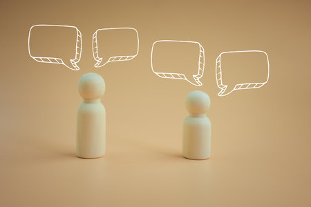 Wood peg doll with pop up of empty speech bubbles. A speech bubble indicating conversation in life