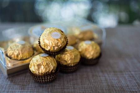 Bangkok, Thailand - February 29, 2024 : Ferrero Rocher, chocolates with crunchy wafer shell and hazelnut filled with chocolate wrapped in golden paperのeditorial素材