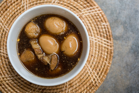 Closed up stewed eggs and pork belly in black sweet sauce, traditional and popular Thai foodの写真素材