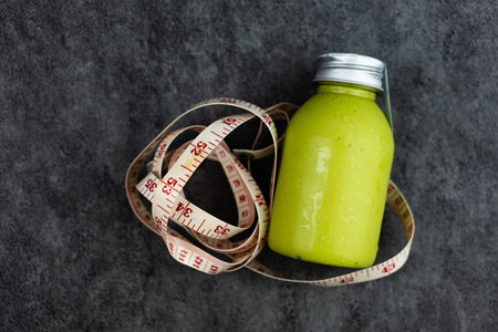 Avocado smoothie in bottle with tape measure. Food and drinks lifestyle concept for healthy. Lose weight healthy eating diet control concept.の写真素材