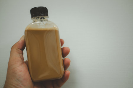 A bottle of cold latte, fresh drink sweet refreshment in handの写真素材