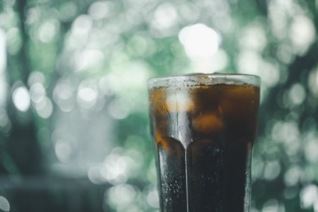 Iced Americano black coffee in glass against nature background