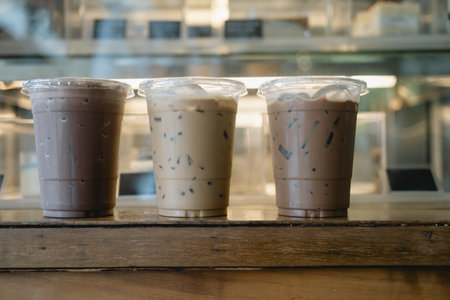 Glass of iced coffee mocha, iced coffee latte and iced chocolate on wood counter bar at cafe with blurred backgroundの写真素材
