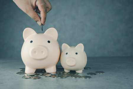 Man putting money into piggy bank, savings, investment or hand putting a coin into a piggy bank to save for future growth and financial freedom. A retirement fundの写真素材