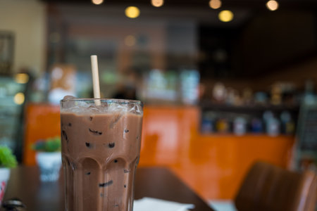Iced chocolate milkshake drink in a glass with white paper strawの写真素材