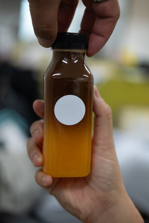 Iced Americano orange juice beverage in plastic bottle with two hand someone