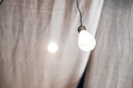 Glowing light bulbs hanging from ceiling for decoration in living room.の写真素材