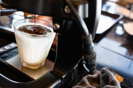 Coffee shot pouring from coffee machine into cold milk for Dirty coffee menu. Specialty coffee.の写真素材