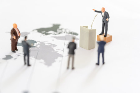Miniature people: Miniature figurine of a politician speaking to the people during an election rally or an executive speaking to the shareholders on world mapの写真素材