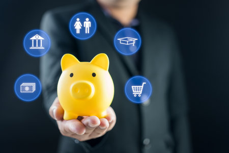 Businessman holding piggy bank with icons of planning family life, insurance, education, saving money wealth, shopping, investment and emergency fund. Savings and finance conceptの写真素材