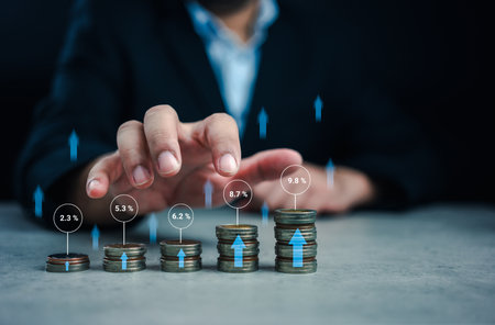 Stacking coins different heights with percentages for interest rates from different investment. Interest rates continue to increase, stock market volatility, taking high investment fund managementの写真素材