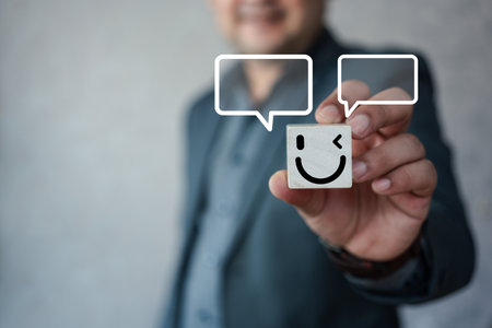Man holding wooden block paint smile happy face and speech bubble, good feedback rating, think positive, customer review, assessment, satisfaction, calm mood, good mental health, good mood.の写真素材