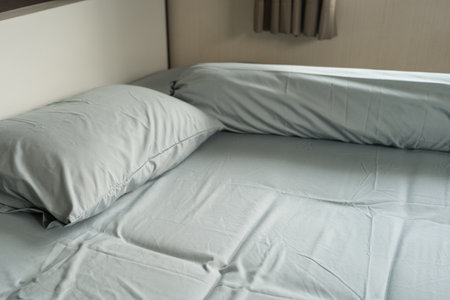 Closeup of pillows and bolster on a simple blue bedの写真素材