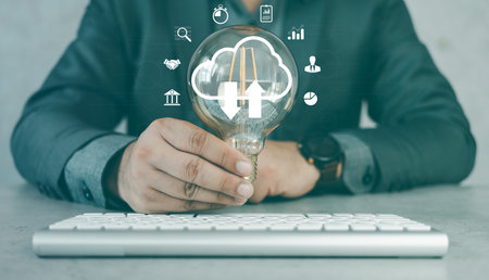 Businessman holding a light bulb and creative light bulb with marketing network icons on planning...